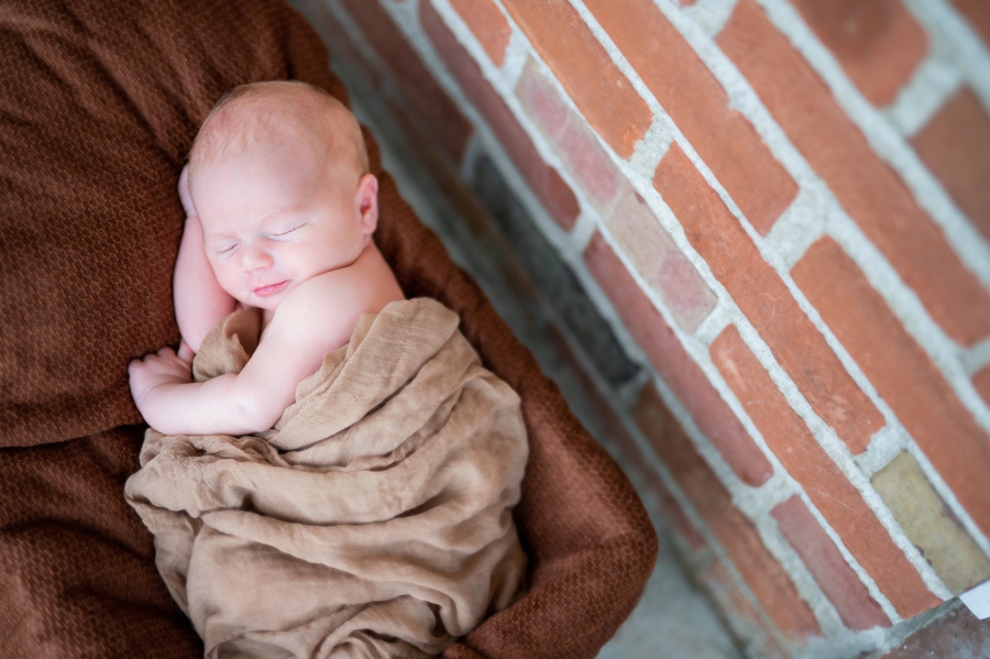 newborn photo with brick wall
